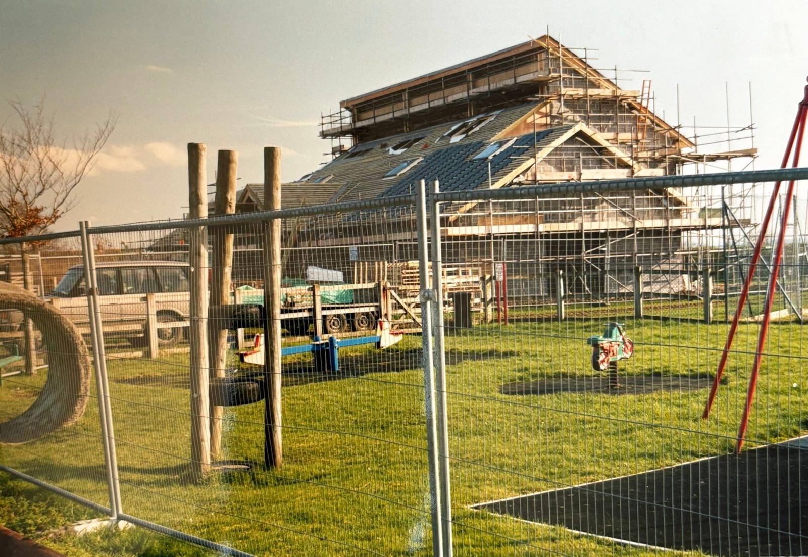 The Village Hall under construction, with scaffolding, beside the old play area